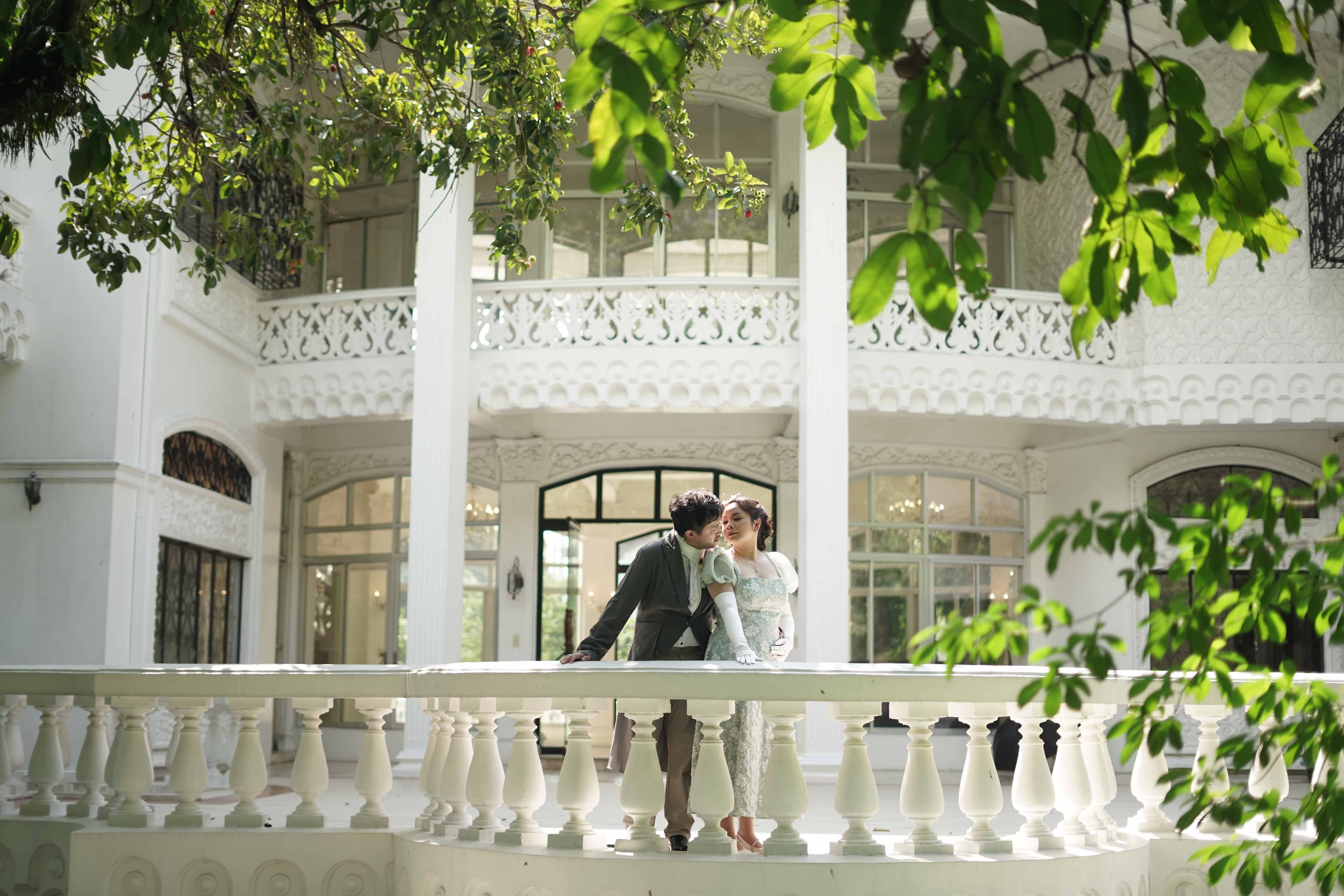 Miko and Jonalyn embracing in Regency-era attire beneath a garden chandelier